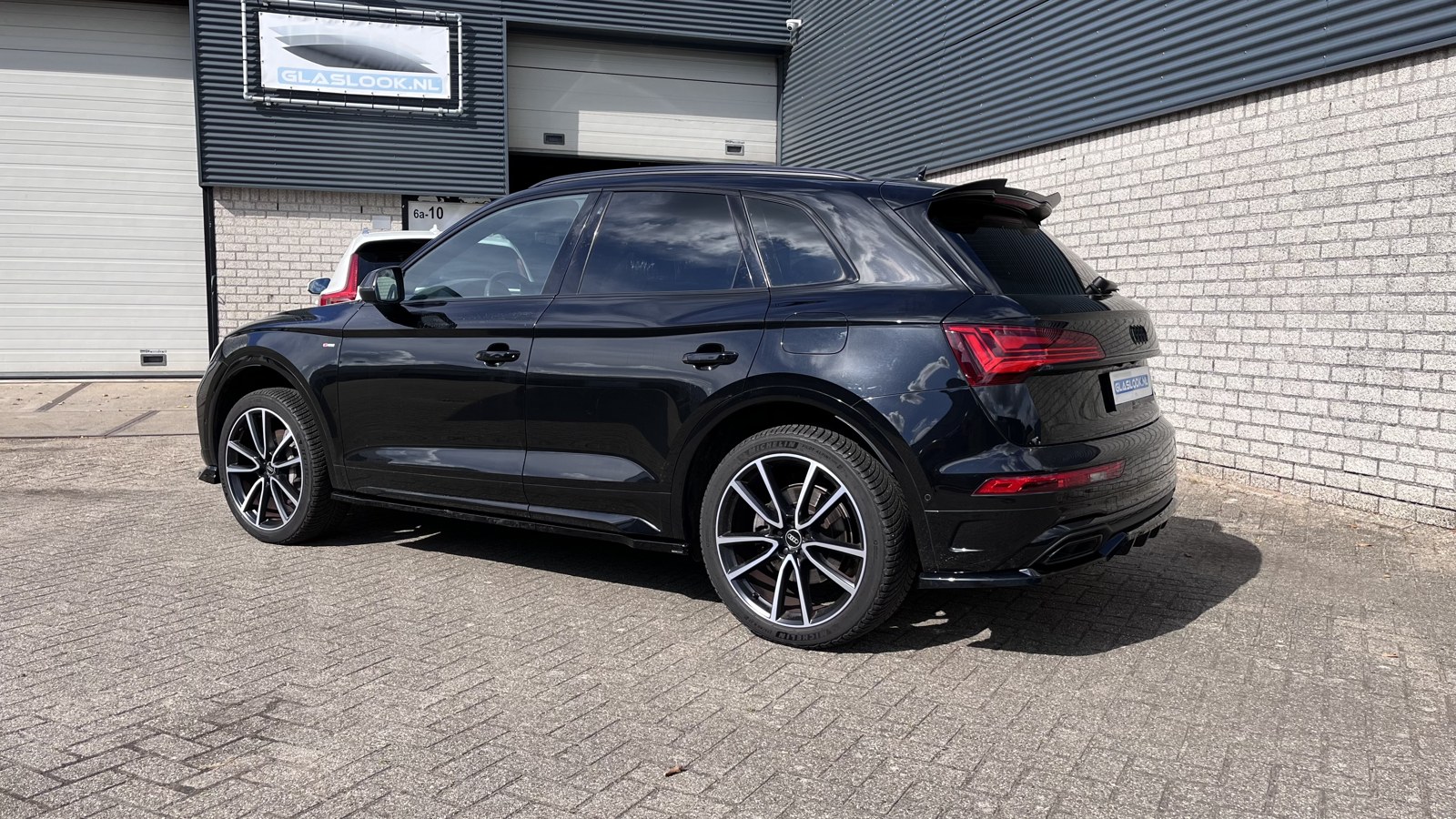 Zwarte Audi met getinte ruiten voor de werkplaats van Glaslook