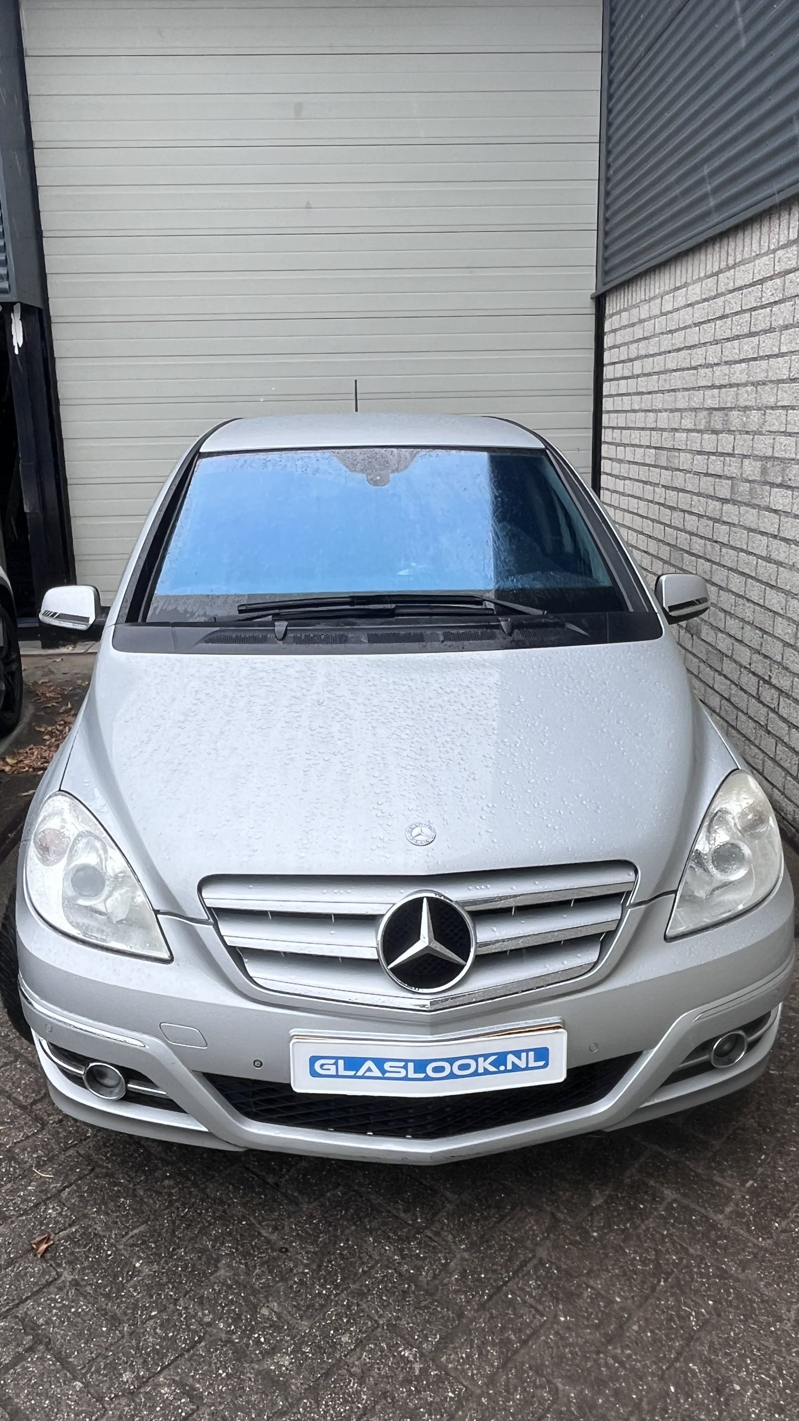 Zilveren Mercedes met blauwe reflectie op de voorruit