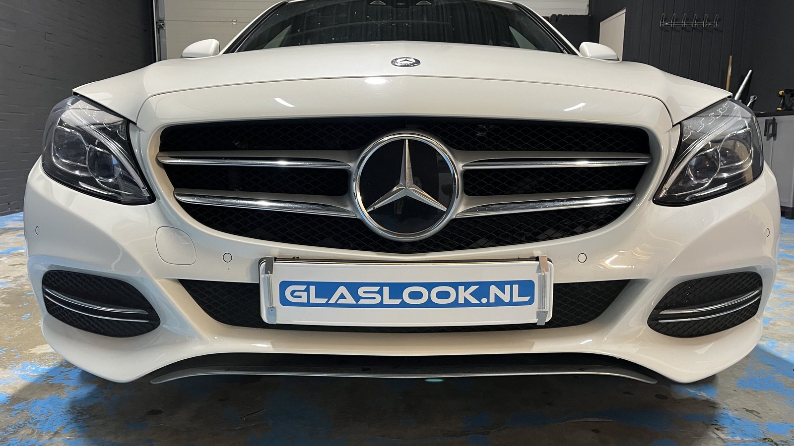 Voorzijde van een witte Mercedes met de originele heldere koplampen